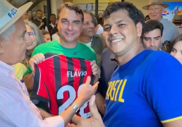 Flávio Bolsonaro repete gesto do pai e posa com camisa do Vitória